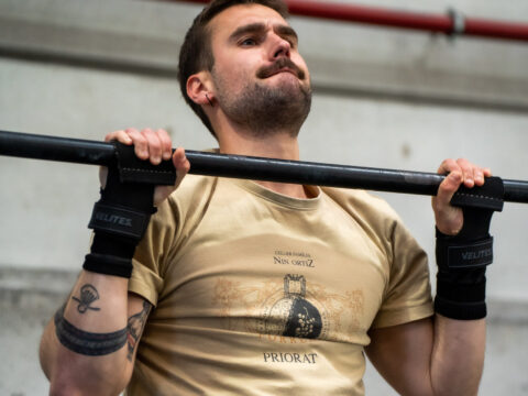 Deportista realizando dominadas con calleras en CrossFit.