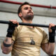 Deportista realizando dominadas con calleras en CrossFit.